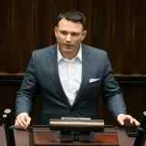 Sławomir Mentzen w garniturze przemawia, zastanawiając się, czy Sławomir Mentzen wykorzystuje AI do pisania swoich postów w kampanii prezydenckiej.