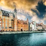Malownicze kamienice nad Motławą, symbol gdańsk stare miasto, pod burzowym, złocistym niebem.