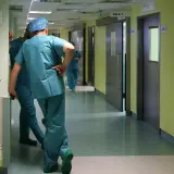 Lekarze w zielonych fartuchach idą korytarzem szpitalnym. Zastanawiasz się, ile zarabia lekarz?