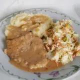 Mięciutki schab w sosie, podany z purée ziemniaczanym i surówką z kapusty. Pyszny obiad gotowy!