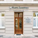 Elegancka fasada gabinetu medycyny estetycznej "Marta Jasiewicz" z drewnianymi drzwiami i oknami.