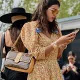 Kobieta w kwiecistej sukience i okularach przeciwsłonecznych, z torebką Fendi, uosabia styl boho moda.