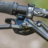 Close-up of a SRAM Level Ultimate brake lever on a mountain bike handlebar, ready for any trail.