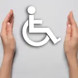 Symbol wózka inwalidzkiego otoczony dłońmi. Symbolizuje wsparcie dla osób z niepełnosprawnością, np. po mastektomii.