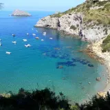 Ein **Geheimtipp Toskana Strand**: Türkisblaues Wasser, kleine Boote und ein sonniger Strand mit bunten Sonnenschirmen. Ein idyllischer Ort zum Entspannen.