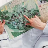 Dłoń wskazująca palcem na mapę Nałęczowa z zaznaczonymi atrakcjami.