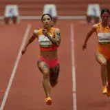 Ewa Swoboda biegnie po rekord na 100 m. Widać jej tatuaże i skupienie na twarzy.