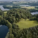 Malownicze jeziora i lasy tworzą magiczne miejsca na Podlasiu. Widok z lotu ptaka na zielone wzgórza i spokojne wody.