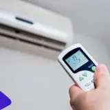 Mando a distancia ajustando el aire acondicionado a 19°C para disfrutar del frío.