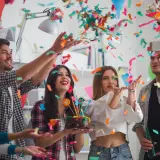 Jóvenes celebran un cumpleaños con confeti y pastel. ¡Una fiesta divertida para saber como vestir para un cumpleaños!