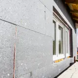 Panneau de polystyrène gris pour isolation exterieur finition. Fenêtre blanche installée. Chantier en cours.