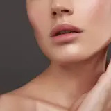 Labios rosados y piel luminosa, con un sutil **contouring cara alargada** que realza la estructura facial.