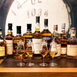 Rząd butelek whisky, w tym Dalwhinnie 15, Balvenie 12, Jura, Oban, Glenmorangie, Monkey Shoulder. Czy warto kupować whisky bez określenia wieku (NAS)?