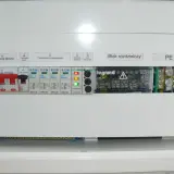 Zabezpieczenie kontrolek faz w rozdzielnicy elektrycznej. Widoczne wyłączniki, ochronniki przepięciowe i blok rozdzielczy.