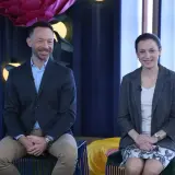 Tomasz Wasilewski i kobieta siedzą na kanapie w studiu telewizyjnym.