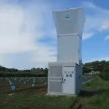 Un canon anti-grêle SPAG se dresse dans un vignoble, prêt à protéger les jeunes plants des orages.