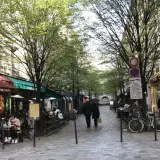 Spacerem w paryskiej dzielnicy Le Marais, z kawiarniami i sklepami po bokach, wczesną wiosną.