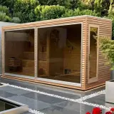 Moderne Gartensauna mit Glasfront, die zum Entspannen einlädt. Ein Traum, wenn man eine Sauna bauen möchte.
