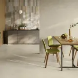 Pavimento cucina idee: un ambiente moderno con tavolo in legno, sedie verdi e una cucina a vista.