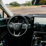 Wnętrze Lexusa z ekranem multimedialnym, na którym widać opcje radia i nawigacji, sugerujące android auto aktualizacja.