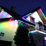 Kolorowe taśmy LED ozdabiają dach i balkon domu, tworząc magiczną atmosferę. Idealne, jakie ledy do pokoju, by rozświetlić noc.