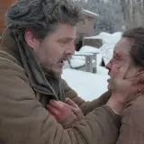 Joel w śnieżnej scenerii, z krwawymi śladami na twarzy, trzyma za podbródek rannego Ellie. To mocna scena, która pokazuje, jak ważna jest obsada w budowaniu napięcia.