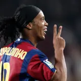 Piłkarz Ronaldinho w koszulce Barcelony, z charakterystyczną opaską na głowie i kucykiem, pokazuje dwa palce. Ile Ronaldinho ma lat?