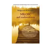 Okładka książki "Miłość nad rozlewiskiem" Małgorzaty Kalecińskiej. To kolejna część sagi nad rozlewiskiem, przedstawiająca drewniane molo o zachodzie słońca.