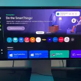 Ekran monitora z interfejsem Tizen, prezentujący aplikacje SmartThings, zdalny dostęp do PC i inne funkcje.