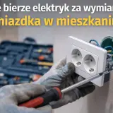 Elektryk w rękawicach dokonuje wymiany gniazdka, używając śrubokręta. W tle widoczna skrzynka z narzędziami.
