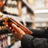 Ręce trzymają butelkę whisky, zastanawiając się, ile alkoholu można przewieźć samolotem z USA do Polski.