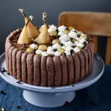 Charlotte poire chocolat, un gâteau élégant avec des poires pochées dorées, de la crème fouettée et des éclats de chocolat.