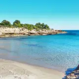 La cala vidre, con su arena dorada y aguas cristalinas, invita a un baño refrescante bajo el sol.