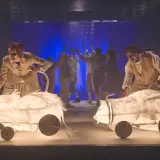 Aktorzy Teatru Lalki i Aktora Wałbrzych prowadzą świetliste, papierowe zwierzęta na scenie.