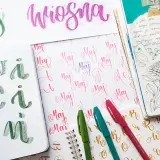 Artystyczny styl pisania. Na zdjęciu widać litery "maj" i "wiosna" wykonane różnymi technikami kaligrafii.