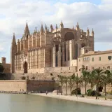 La Catedral de Mallorca, un impresionante edificio gótico, se alza majestuosa junto al mar, evocando la grandeza de Barcelona.