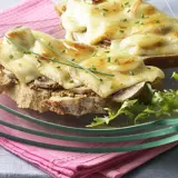 Tartines gourmandes avec une généreuse croute de fromage fondue, garnies de champignons et de ciboulette.