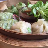 Parowóz z dim sum: zielone i białe pierożki z sosem i sałatką.
