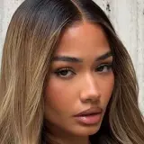 Mujer con cabello castaño oscuro con mechas rubias, un estilo que inspira cómo aclarar el pelo para un look radiante.