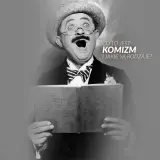 Aktor z wąsami i kapeluszem, z otwartymi ustami, czyta książkę. Tekst pyta o **komizm** i jego rodzaje.