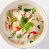 En skål med krämig tom kha gai med kyckling, svamp, chili och koriander.