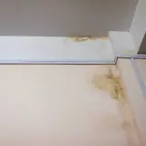 Taches de moisissure et d'humidité au plafond et sur le mur, preuves pour se défendre contre une accusation de vice caché maison.