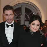 Adriana Kalska z partnerem na czerwonym dywanie, uśmiechnięci i eleganccy.