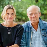Anna Hedelius och en man sitter utomhus.