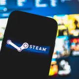 Telefon z logo Steam. Chcesz wiedzieć, jak sprawdzić ile się wydało na Steam? Zobaczysz tu podpowiedź.