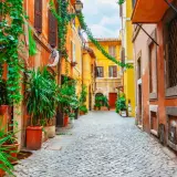 Un vicolo fiorito a Trastevere, Roma. Un luogo incantevole per scoprire cosa fare a Trastevere, tra piante rigogliose e case colorate.