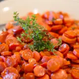 Carottes Vichy cookeo, tendres et glacées, garnies d'une branche de thym frais. Un délice simple et savoureux.