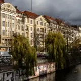 Berliner Altbauten am Wasser, mit Weiden und Graffiti. Hier gibt es viele Berlin Insider Tipps zu entdecken.