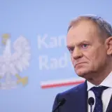 Donald Tusk w garniturze, za nim godło Polski. Czy prezydent ma prawo ogłosić referendum w sprawie CPK bez zgody sejmu?