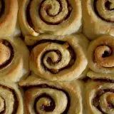 Nybakade kanelbullar med russin, redo att avnjutas. Doften av kanel sprider sig i köket.